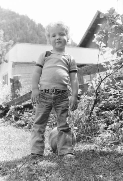 istock Vintage low angle image of a young boy with flare pant jeans 1294986064