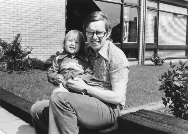 Photo of Retro monochrome portrait of father and daughter sitting in a garden