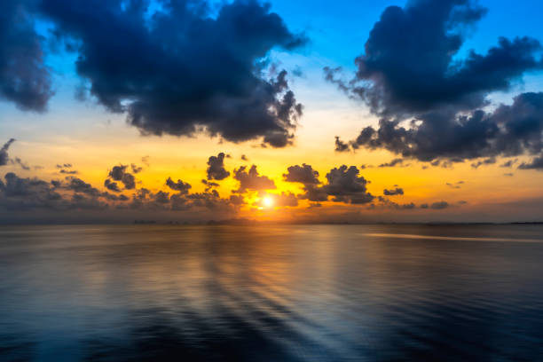 istock sun on sunset sky at the lake with silhouette mountain and clouds. 1294986927