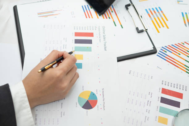 istock Asian accountant working and analyzing financial reports project accounting with chart graph and calculator in modern office, finance and business concept. 1294991079