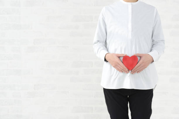 istock Pregnant woman with heart object on white background 1294991177