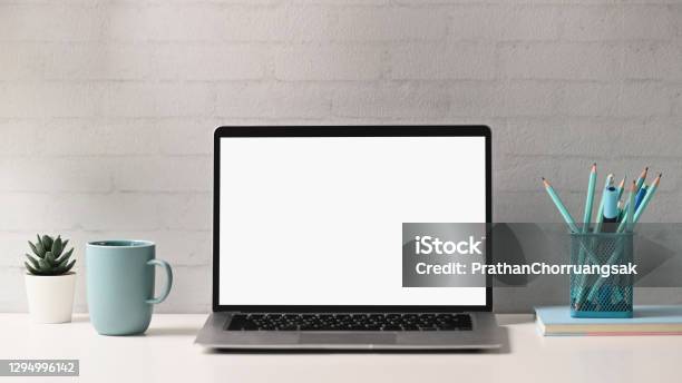 Front View Of Mock Up Laptop Computer With Blank Screen Notebook Stationery Coffee Cup And Brick Wall At Creative Designer Workspace Stock Photo - Download Image Now