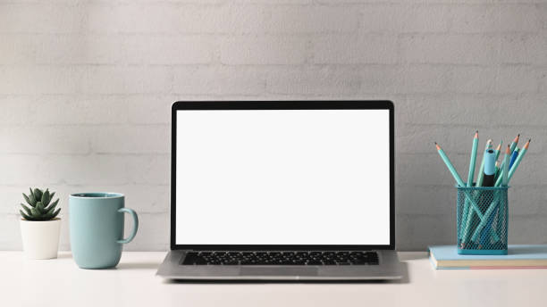 vista frontal do computador portátil com tela em branco, notebook, papelaria, copo de café e parede de tijolos no espaço de trabalho do designer criativo. - computador - fotografias e filmes do acervo