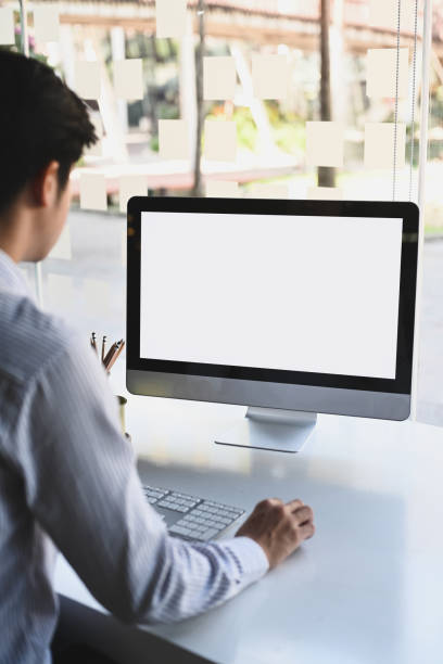 istock Rear view of businessman working with computer while sitting in modern office. 1294996191