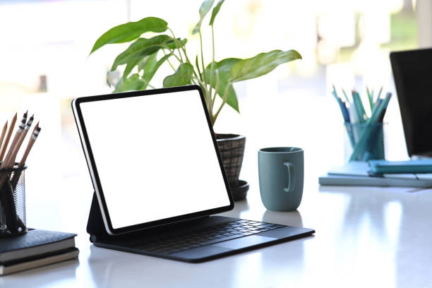 istock Graphic designer workstation with tablet computer, plant, stationery and coffee cup on white table. 1294996264