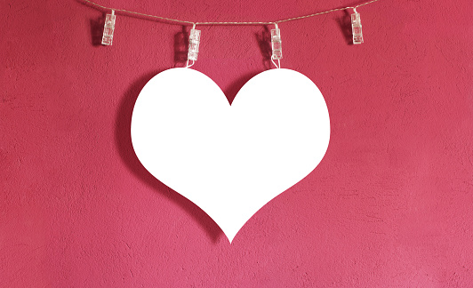 Mockup paper cut heart hanging on a laundry string. Copy space for text or aditional content.
