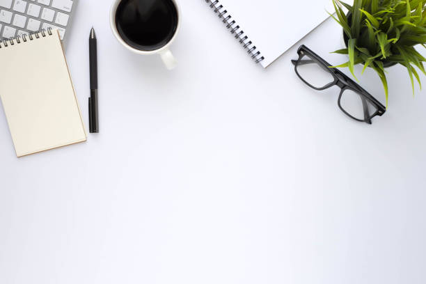 istock Top view above of White office desk table with keyboard, notebook and coffee cup with equipment other office supplies. Business and finance concept. Workplace, Flat lay with blank copy space. 1294998879