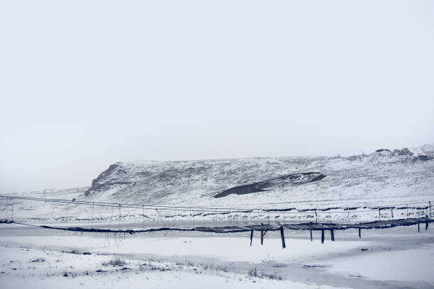 istock Old hanging footbridge in winter 1295002511