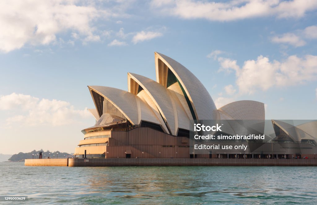 Sydney Opera House In The Morning Sun Sydney Australia - August 5, 2017: A bright day in Sydney, New South Wales, and this is the view looking across the Harbour towards the iconic shape of the city's Opera House. Sydney Opera House Stock Photo