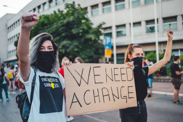 istock Young protestant women holding a poster with text 