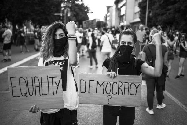 istock Young women protesters holding placards 1295003807