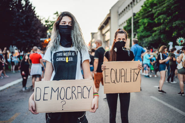 istock Young women protesters holding placards 1295003842