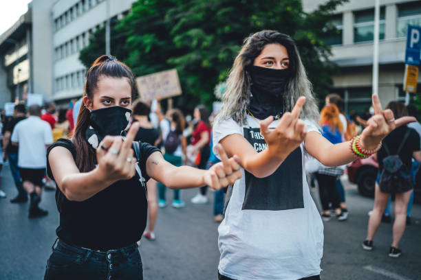 istock Young female protesters showing middle finger 1295003994
