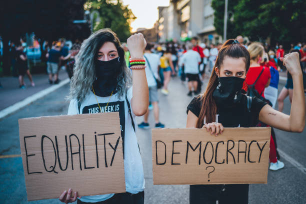 istock Young women protesters holding placards 1295004010