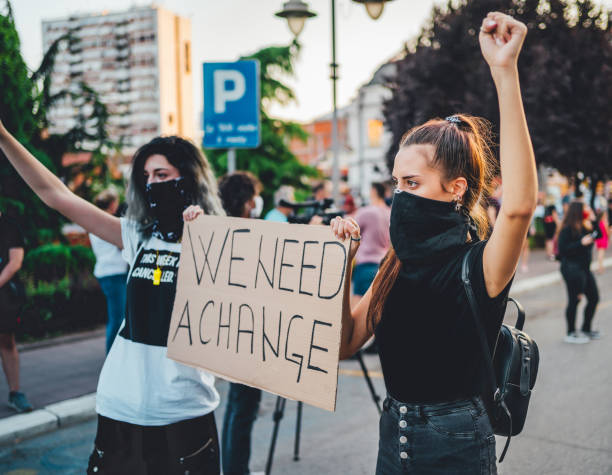 istock Young protestant women holding a poster with text 