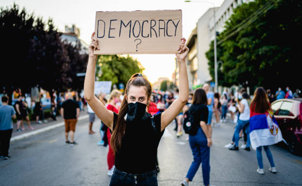 istock Young woman protester holding placard with text 