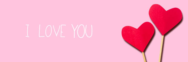 istock Composition Valentine's Day. Heart on a stick on a pink background. Banner. Flat lay, top view 1295005218