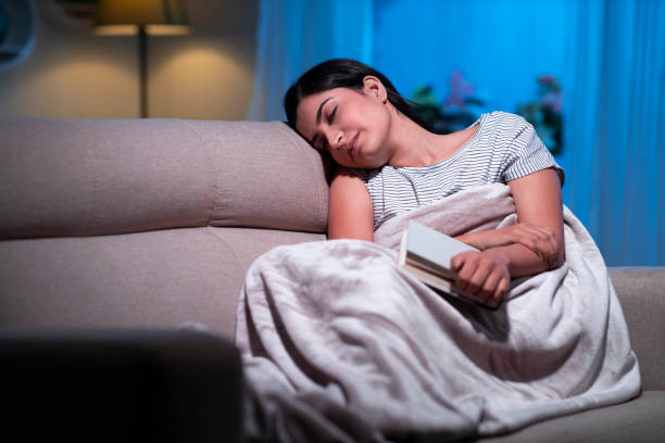 istock young women reading book at home sitting on sofa 1295006128