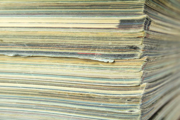 istock Stack of old shabby magazines. Side view with bokeh effect. 1295008719