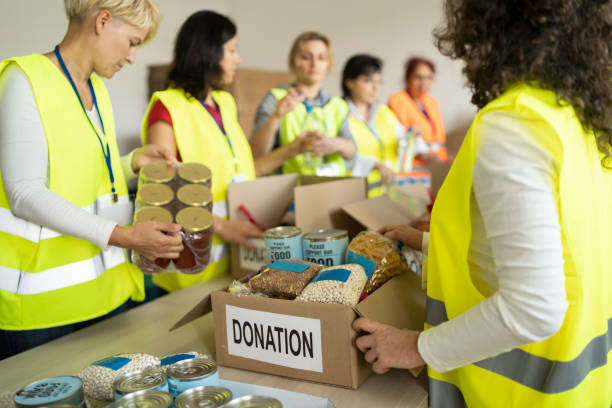 istock Volunteers packing donation box with food 1295008989