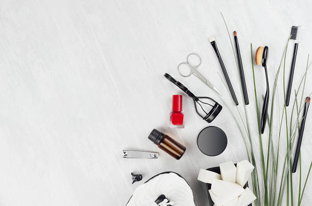 istock Spring fresh elegant black makeup accessories and cosmetic products with green grass and red nail polish on white wood background, top view, copy space. 1295011232