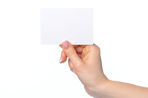 istock Woman's hand with blank white business card isolated on white 1295011527