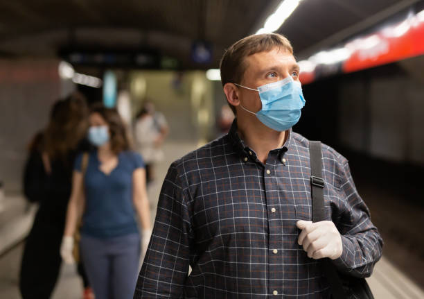 istock Man in medical mask on subway platform 1295012692