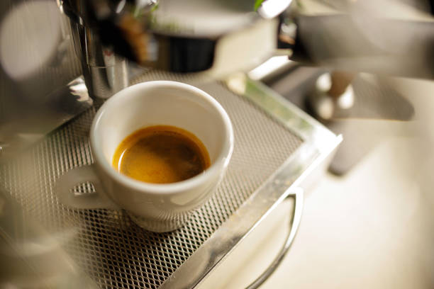 istock cup of espresso being poured from an espresso machine 1295017142