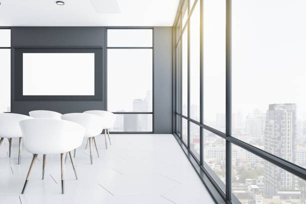 istock Presentation room with blank screen and city view. 1295018407