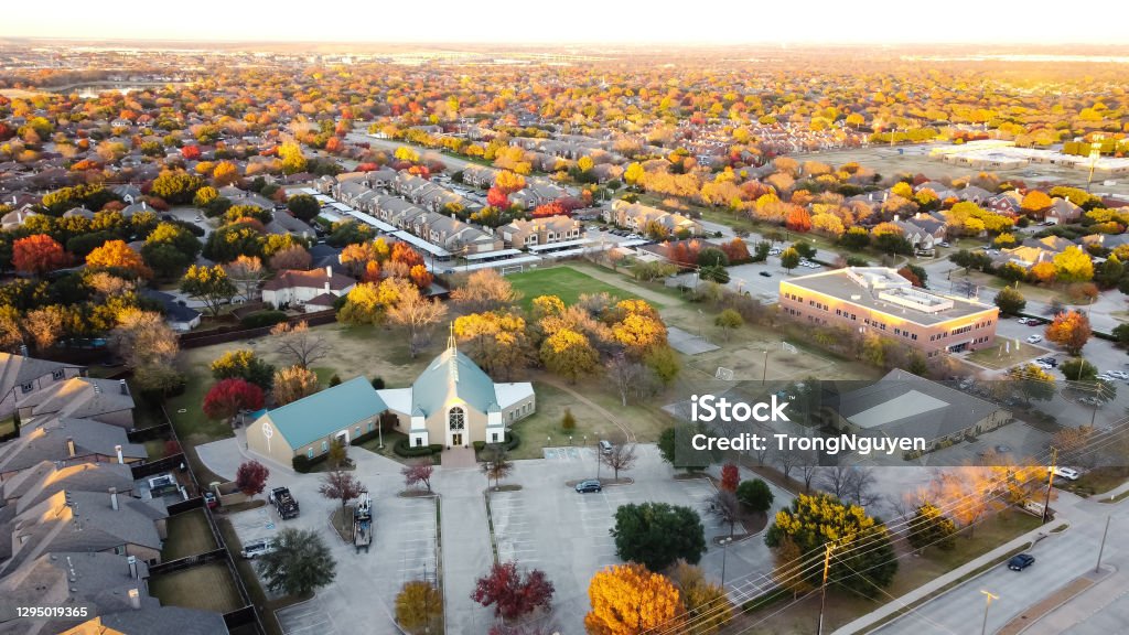 Aerial view new suburban houses neighborhood with church and master planned community in Coppell, Texas, USA Top view new development houses with church and subdivision sprawl in background and colorful autumn leaves near Dallas, Texas, America Texas Stock Photo