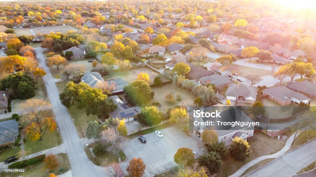 Top view suburban church blended in residential area with autumn leaves in Coppell, Texas, USA Aerial view suburban church near residential neighborhood at sunset with colorful fall foliage near Dallas, Texas, America Above Stock Photo
