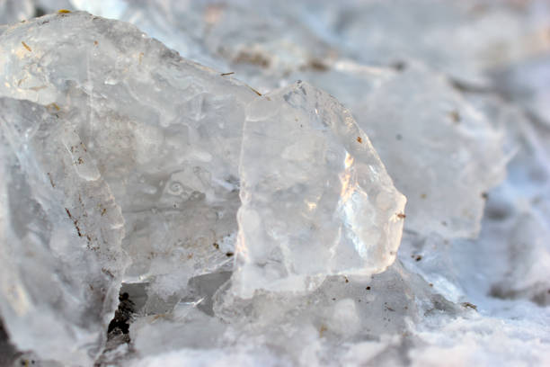 istock Blocks of multicolored transparent ice in winter with mud 1295023452