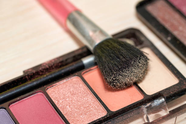 istock Open Box of Multicolored Eyeshadow with Makeup Brush. Close up 1295024368