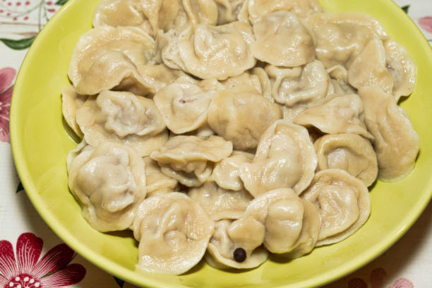 istock Cooked dumplings in a green plate on the dining table. Close up 1295024401