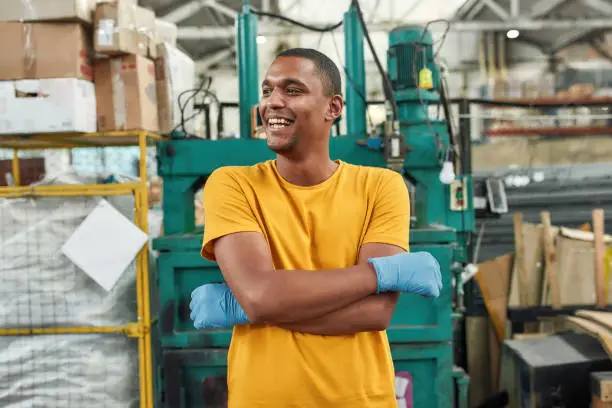 Photo of Cheerful man standing on waste compressing machine background