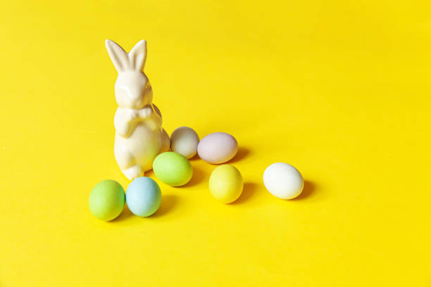 istock Happy Easter concept. Preparation for holiday. Easter candy chocolate eggs sweets and bunny toy isolated on trendy yellow background. Simple minimalism copy space 1295027164