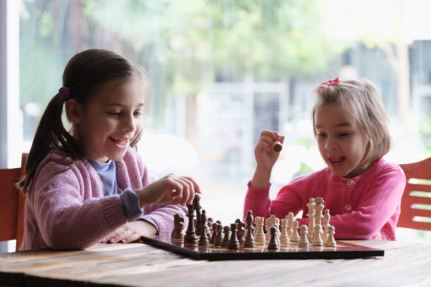 istock Two Little Girls Playing Chess Together 1295027444
