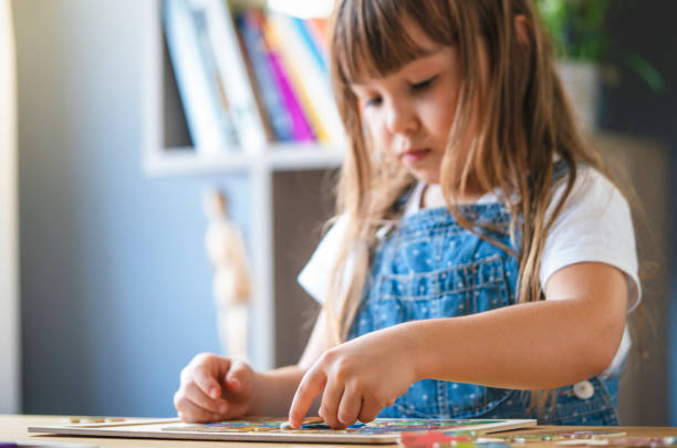 istock Little girl playing with puzzles at home 1295028308