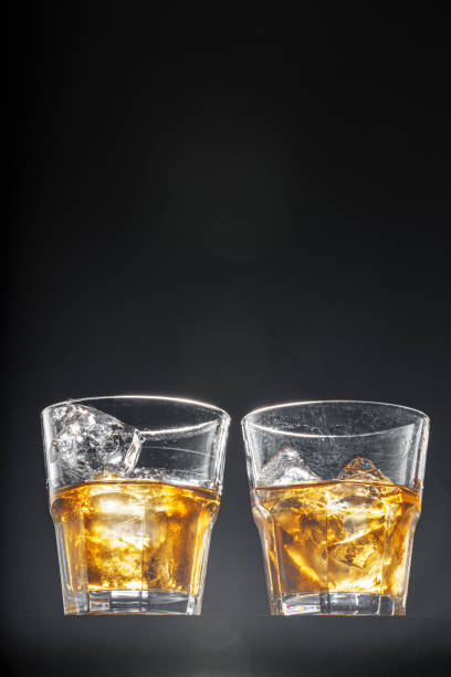 istock Glass of whisky on black background, copy space 1295028501