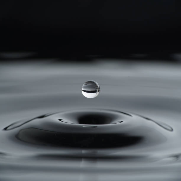 istock Water drop before it hits water isolated with black background 1295029806