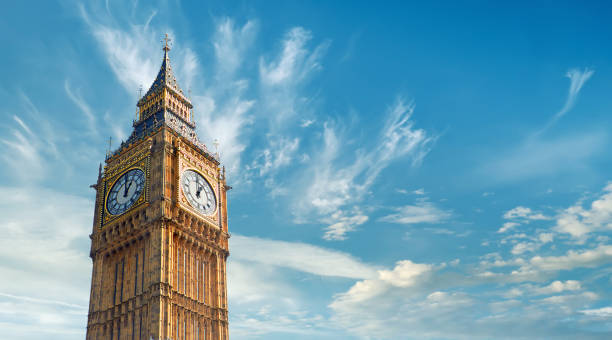 big ben clock tower in london, großbritannien, an einem hellen tag. panoramakomposition mit textraum am blauen himmel mit federwolken - turmuhr stock-fotos und bilder