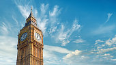 Big Ben Clock Tower in London, UK, on a bright day. Panoramic composition with text space on blue sky with feather clouds