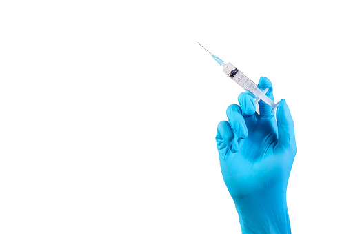 Blue gloved hand holding a medical syringe preparing for injecting vaccine isolated on white background. Health care concept.