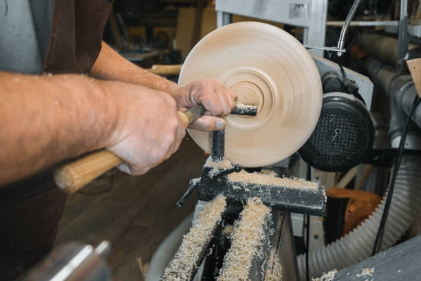 istock a man in a working apron works on a wood turning lathe. hands hold a chisel. hobby 1295032284