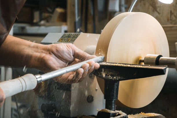 istock a man in a working apron works on a wood turning lathe. hands hold a chisel. hobby 1295032288
