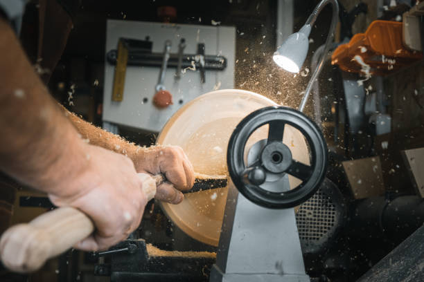 istock a man in a working apron works on a wood turning lathe. hands hold a chisel. hobby 1295032291