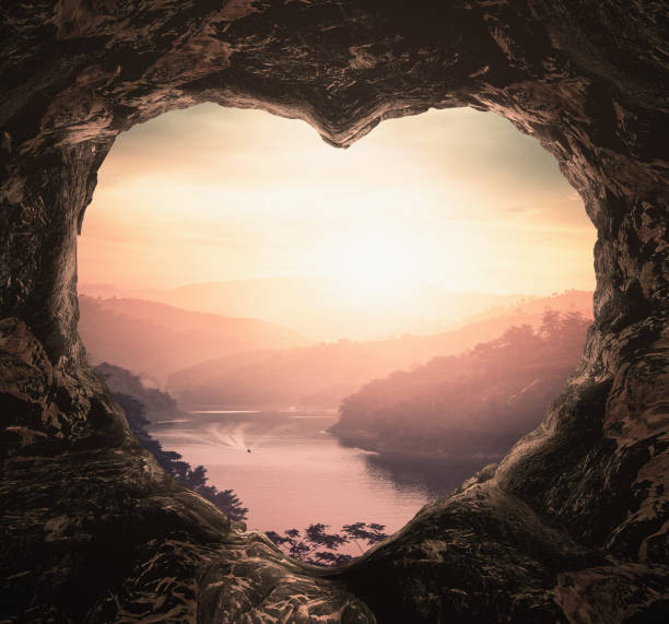 Heart shape of cave on river and mountains sunset background