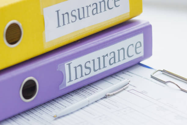 istock Clean insurance form, colored folders and a pen 1295034182