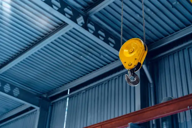 Industrial crane hook in a modern factory building close up