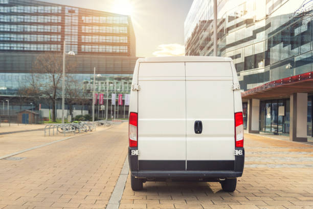 istock Unrecognizable altered delivery van in european city central . Medium lorry minivan courier vehicle deliver package at residential office building in downtown area. Commercial shipping logistics 1295035057